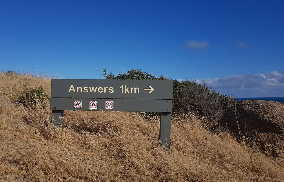 sign on a wilderness trail pointing to 'Answers 1km'