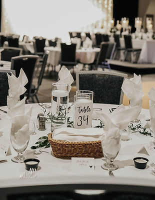Mayo Clinic Health System Event Center Banquet Hall set for a wedding with round tables. The head table and dance floor are shown in the background.