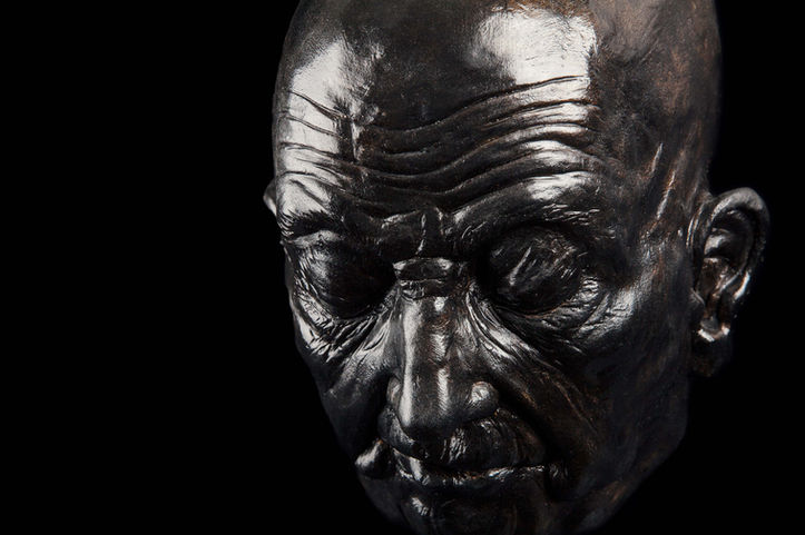 Sculpture réaliste en plâtre patiné noir d'un visage un homme plongé dans ses pensées.