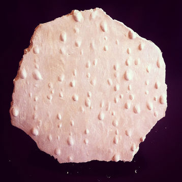 Sculpture de gouttes d'eau sur un mur modelée en argile.