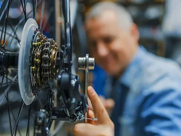Man inspecting a bicycle drive train