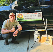 Employee smiling next to equipment and work vehicle