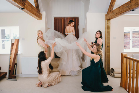 Brides posing holding the wedding train.