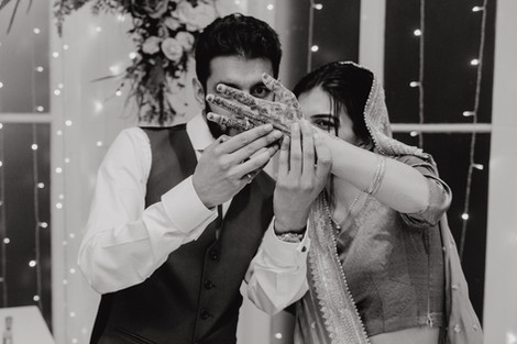 Indian bride shows her hand henna patterns to her groom.