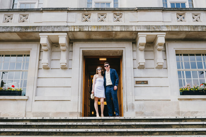 Just married couple standing under the front entrance arch at Hackney Town Hall, London.