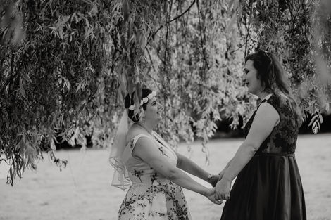 Black and white photo of a lesbian couple holding hands under a tree. Hartsfield Manor Hotel, Betchworth.