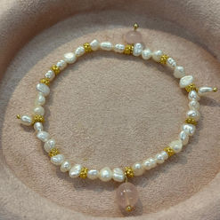 Armband mit Perlen, Edelsteinen und Gold-Elementen.