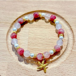 Armband mit Perlen, Edelsteinen, Gold-Elementen und Charms.