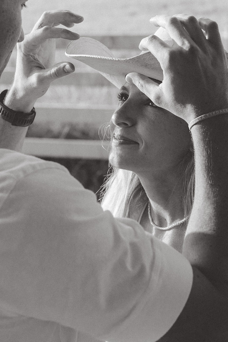 a boy adjusting his fiancé's cowboy hat during Baton Rouge engagement session