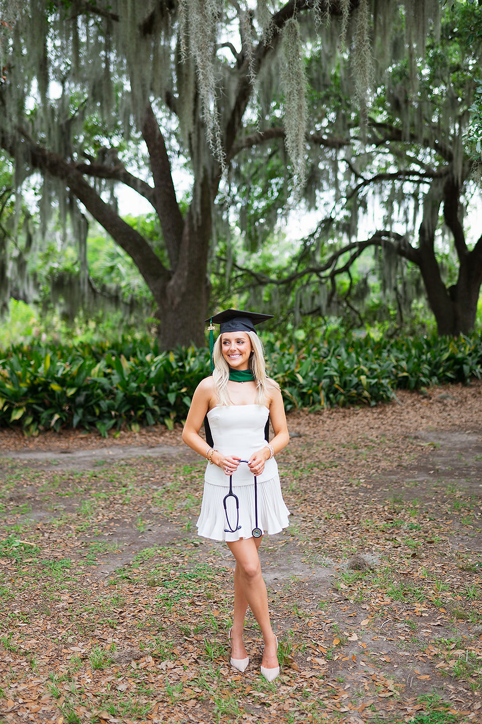 New Orleans PA graduate in her cap and hood holding her stethoscope  