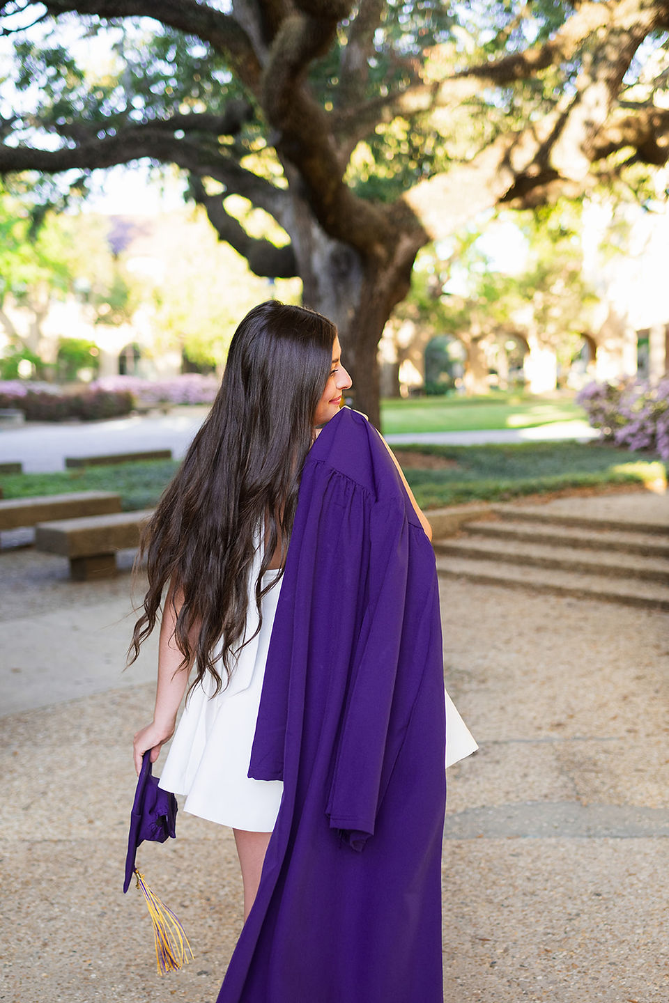LSU senior with her gown draped over her shoulder 