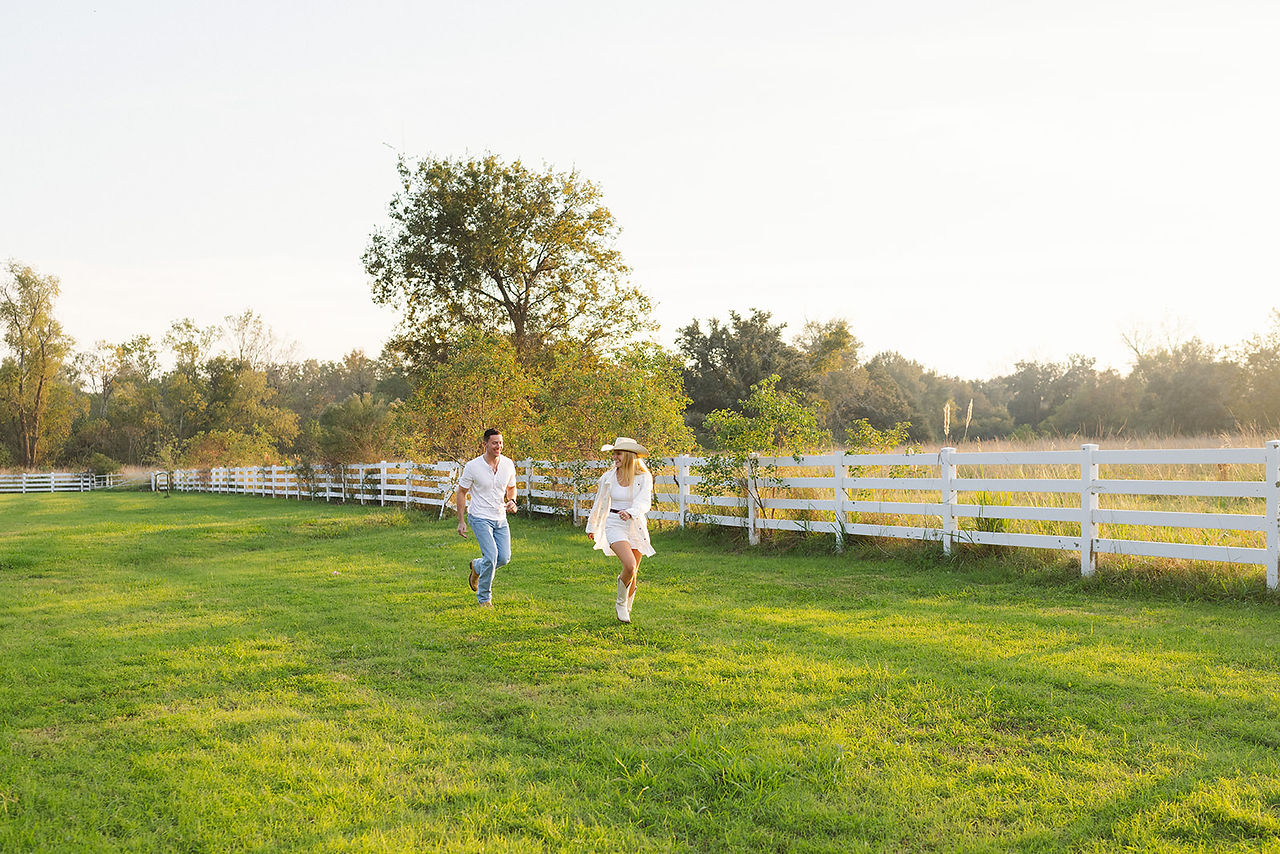 he is chasing her around this open field during Baton Rouge engagement session taken by New Orleans wedding and portrait photographer Sierra Beaulieu