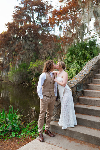 a couple kissing at the bottom of the bridge in New Orleans City Park 