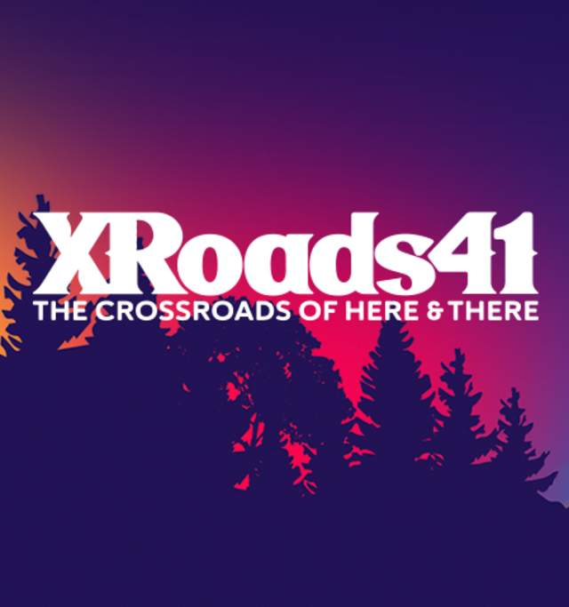 Silhouette of trees against a vibrant sunset sky with "XRoads41: The Crossroads of Here & There" text in bold, white font.