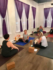 Students practicing the Ashtanga series from their manuals, working diligently towards graduation in the Yoga Teacher Training program at Life Yoga Studio in Milton