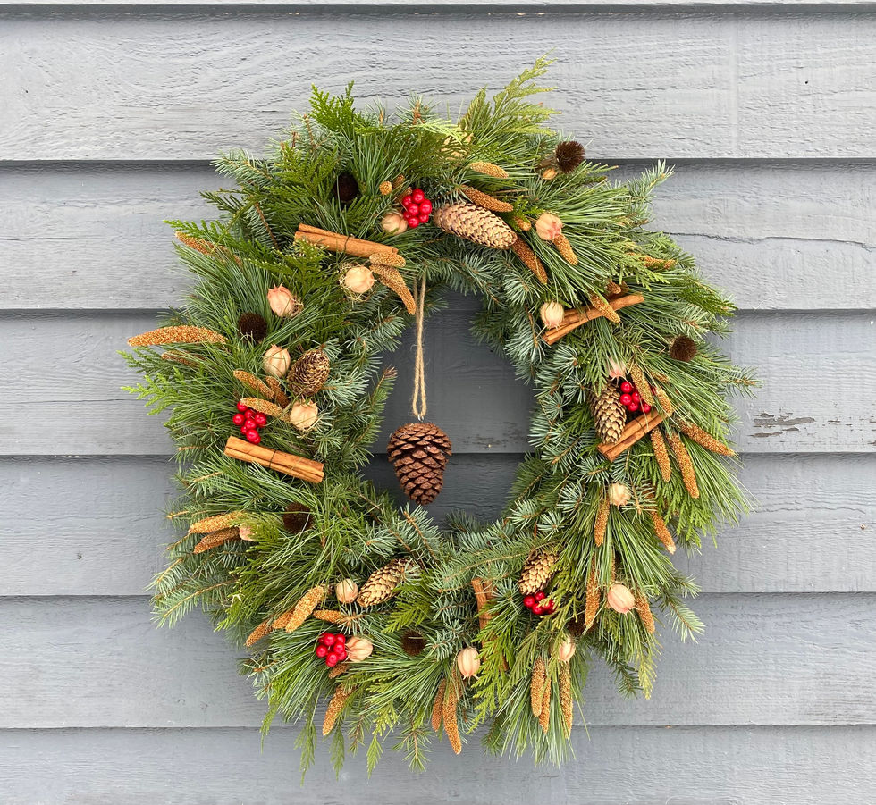Evergreen Christmas wreath decorated with cinnamon, berries, pinecones. Seasonal Wreaths and Swags.