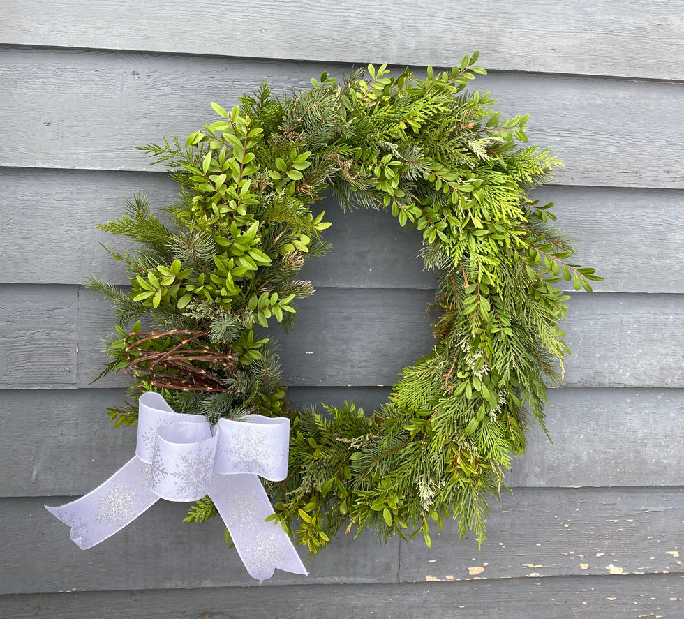 Green foliage wreath with white bow, Seasonal Wreaths and Swags, on gray siding.