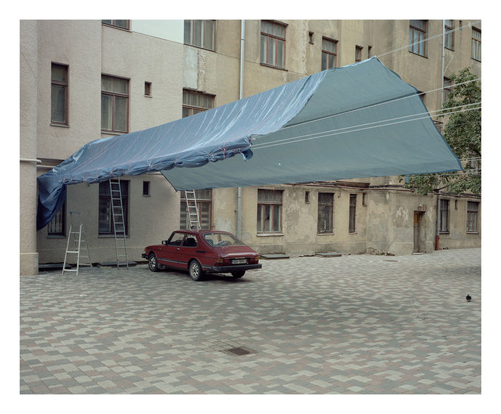 Improvised structure covered with a blue tarp in a residential courtyard