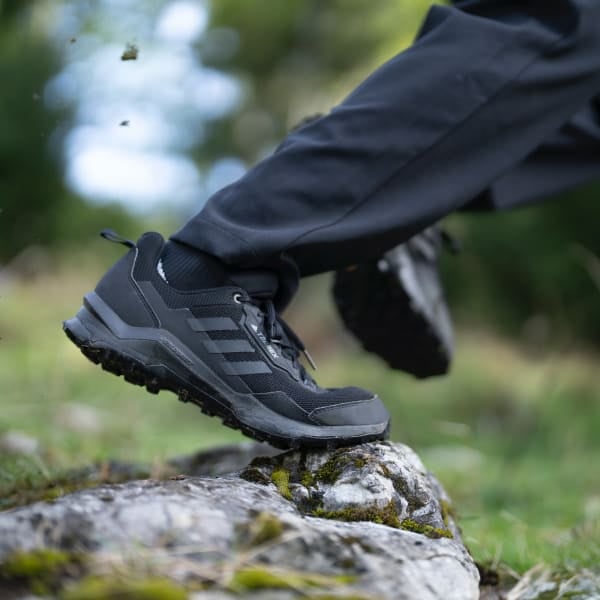 Black Men's Terrex Ax4 Gore-Tex Sneaker stepping on a rock