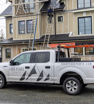 The Four Peaks Power service truck parked at a residential construction site in Langford, BC.