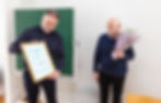 Svanur presents the certificate of recognition and reads its text aloud.