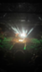 Wide view of a WWE wrestling event in a packed arena, with the ring illuminated at the centre of the crowd.