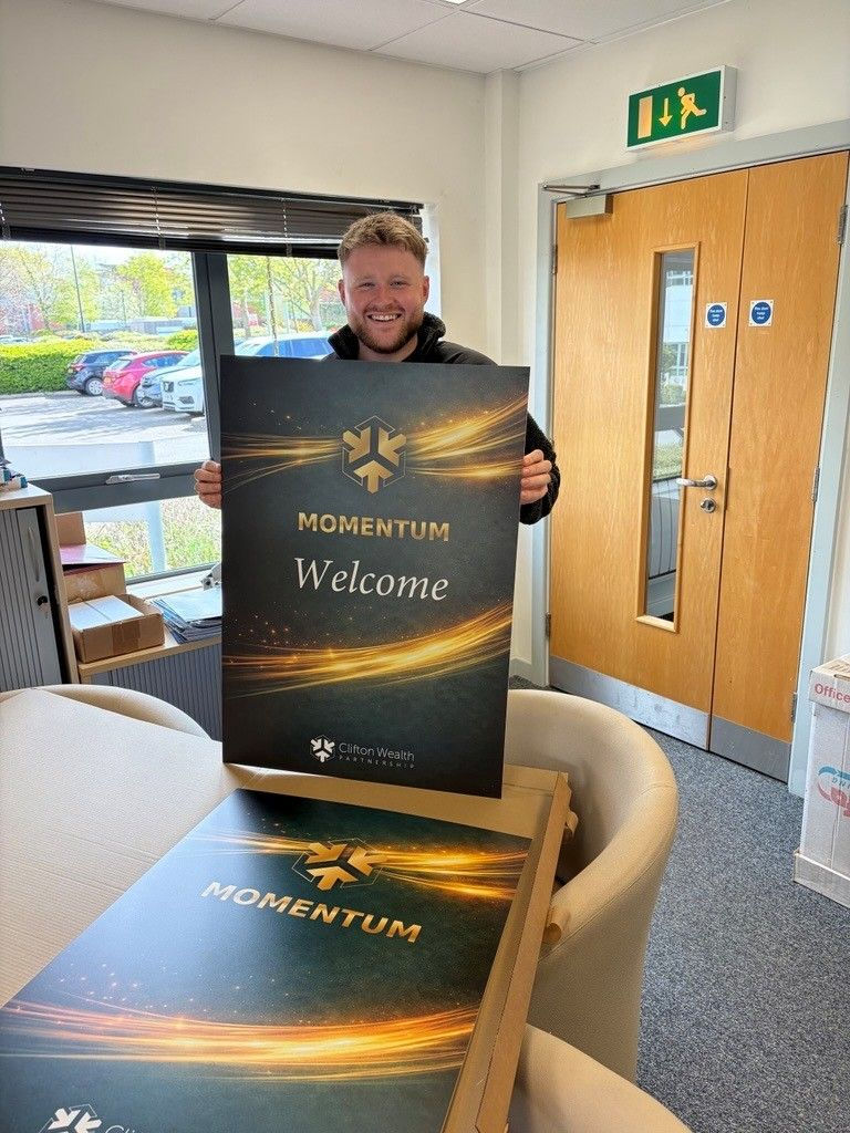 Jacob Hammersley holding Momentum 2026 event signage ahead of Clifton Wealth Partnership's first national adviser conference