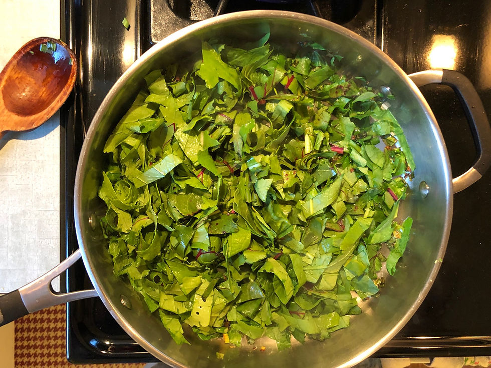 Chopped greens in skillet on the stovetop.