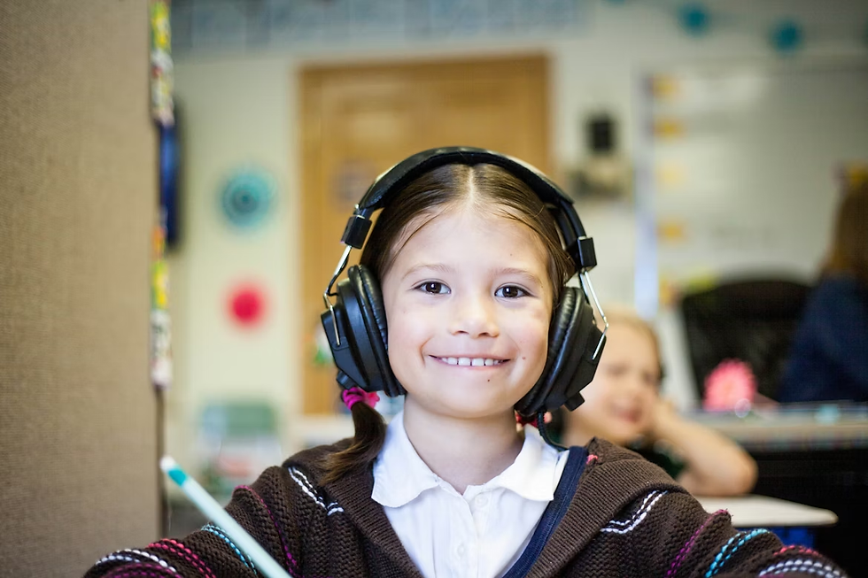 Smiling girl wearing headphones holds a pencil in a colorful classroom, creating a cheerful and focused atmosphere.