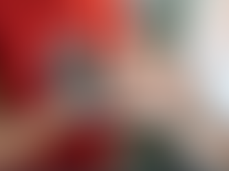 Two people hold hands while looking at an ultrasound photo and a pregnancy test. One wears a red shirt, the other a white one. Emotion: joy.