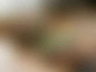 Person serves guacamole in a kitchen with a wooden countertop, Kettle chips bag, lime, herbs, and potted plants near a window.