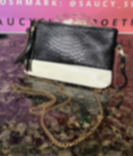 Black and white crossbody bag with gold link chain.