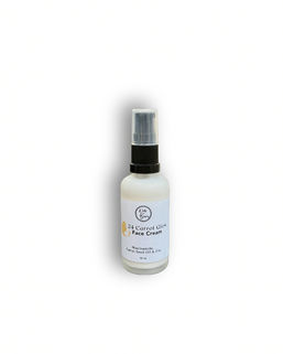 Bottle of Woods and Blooms 24 Carrot Glow face cream with text visible on the label. Niacinamide and zinc skin care product
