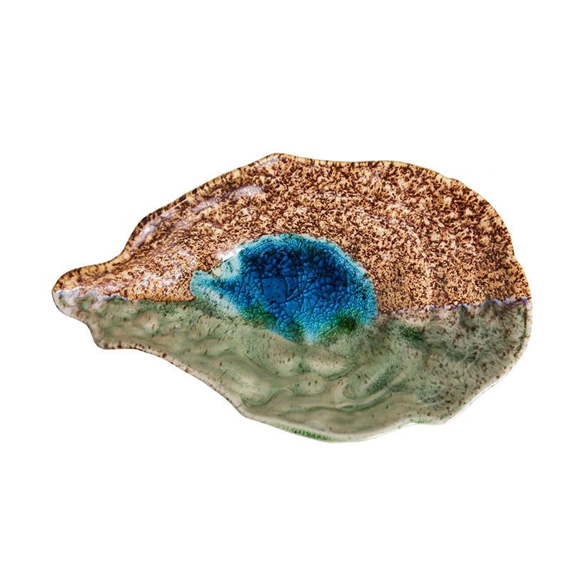 Destaque lateral do design organico do prato de ceramica formato concha.