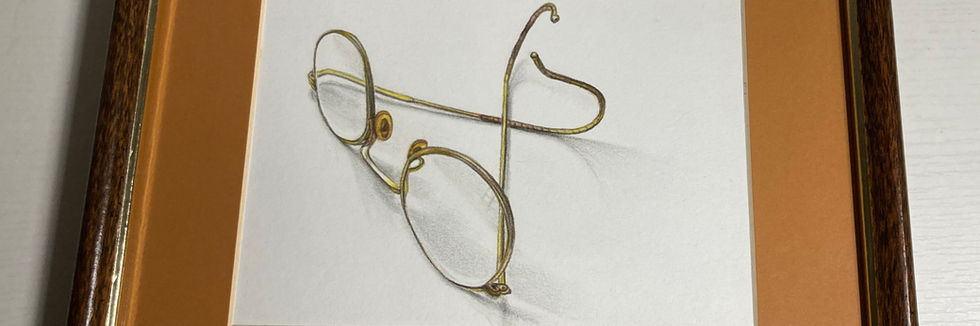 Antique glasses in frame with warm colored mat.