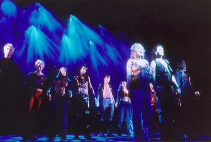 a group of people standing on a stage with blue lights behind them