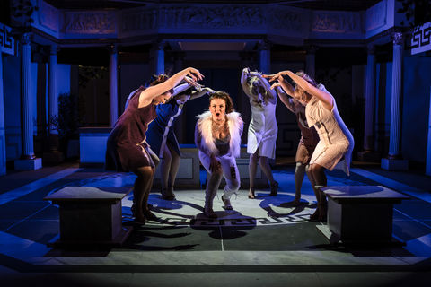 a woman in a white fur coat is surrounded by other women