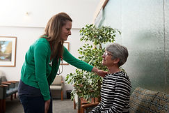 Nurse putting hand on patients shoulder and smiling.