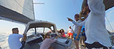 Monohull sailing on a broad reach under full sails, skipper explaining a maneuver to attentive crew, Salty Fundamentals training in Greece.