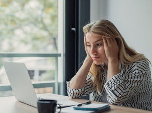 Burnout awareness concept showing a caring professional taking a moment to reflect on the balance between supporting others and supporting themselves.