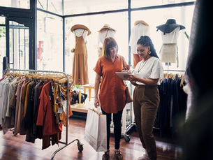 A store assistant speaking to a customer in a clothing store.