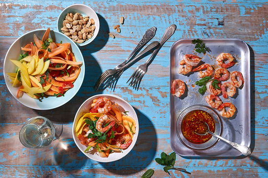 Schrimps auf einem rustikalen Tisch mit Mango Salat