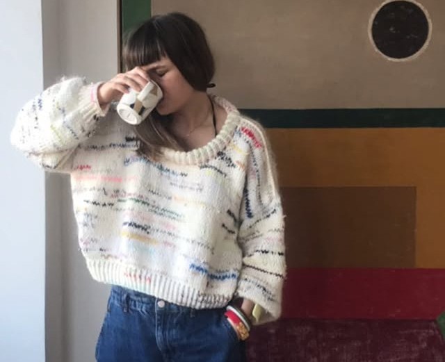 A woman wearing a white knitted sweater