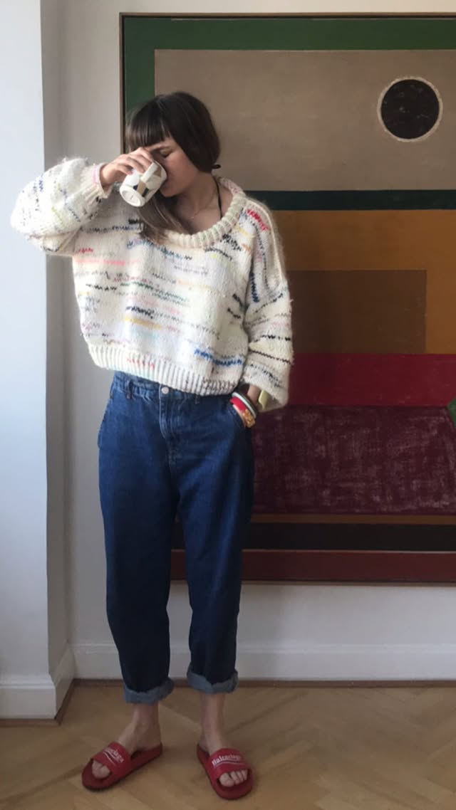 A woman wearing a white knitted sweater