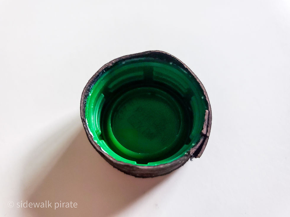 A green bottle cap inside a fabric covering
