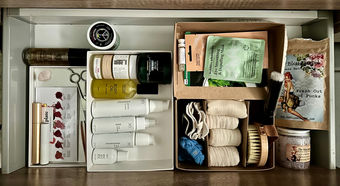beauty products lined up within category boxes, in a large drawer in the bathroom