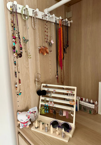 Open wardrobe nook has hooks on the side to hang necklaces, square standing frame has holes and notches for earrings and there is a ring stand too.