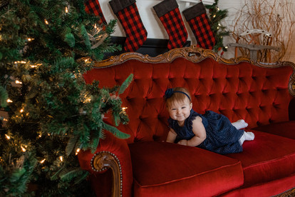 child playing on couch during Christmas mini photos