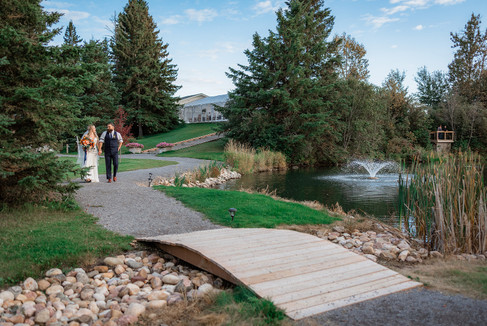 bride and groom walk around Pine and Pond