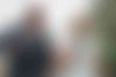 bride and groom walk toward the ceremony laughing